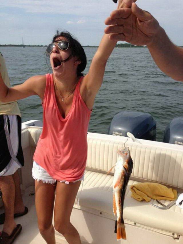 random picture of woman reacting to catching a live fish