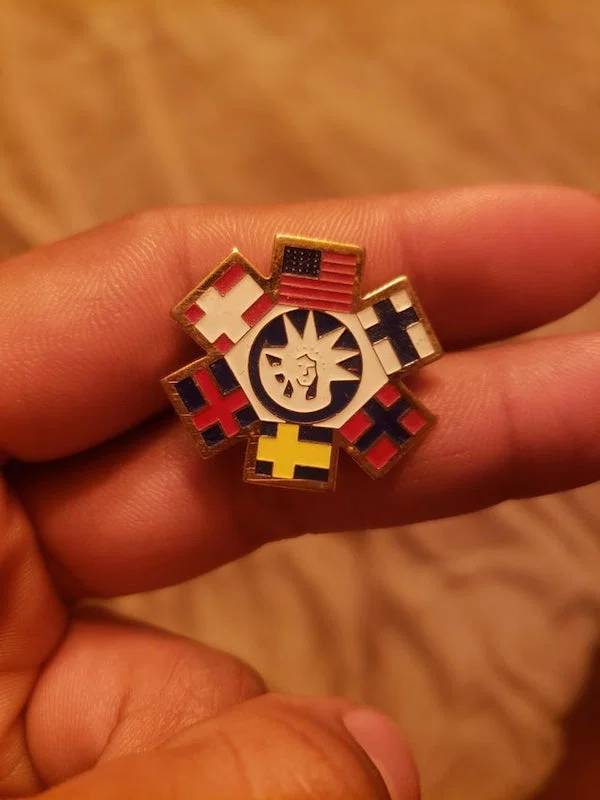 "Northern U.S., a pin from mother’s side of family. Wouldn’t even know how to look it up."A: "It is a commemorative pin for the Statue of Liberty centennial, 1986. There was a “flags of the world” series."