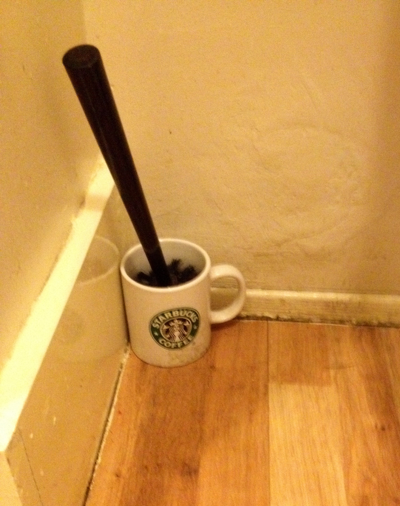 Holder for a toilet scrubber at an independent coffee shop