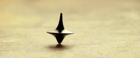 In the movie Inception it seems like the top is Cob's totem, but it's not. Cob says in the movie that the totem is his wife's. He never actually grapples with knowing whether he's awake or not, and he only keeps the top as a symbol of blaming himself for his wife's death. At the end of the film, Cob's walking away from the top represents his letting go of his self-blame, and there's no question of wether or not he's awake.