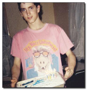 Eminem holding a birthday cake and wearing an Alf t-shirt