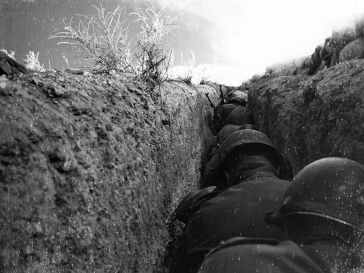 American soldiers hunker down in a trench less than a mile away from the detonation of a 43 kiloton nuclear bomb in 1953