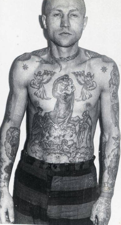 A snake around the neck is a sign of drug addiction. The stars on the clavicles and epaulettes on the shoulders show that this inmate is a criminal authority. The Madonna and child is one of the most popular tattoos worn by criminals — there can be a number of meanings. It can symbolise loyalty to a criminal clan; it can mean the wearer believes the Mother of God will ward off evil; or it can indicate the wearer has been behind bars from an early age.