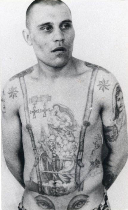 The stars on the shoulders show that this inmate is a criminal authority. The medals are awards that existed before the revolution and, as such, are signs of antagonism and defiance toward the Soviet regime. The eyes on the stomach denote a homosexual (the penis makes the ‘nose’ of the face).