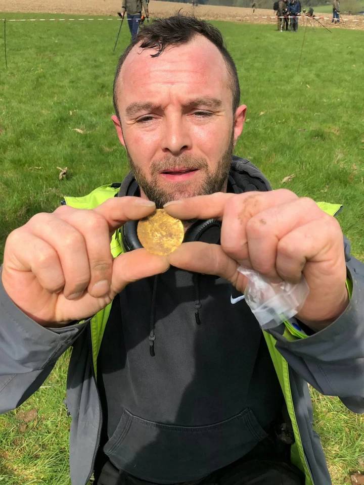 Guy holding a gold coin he found