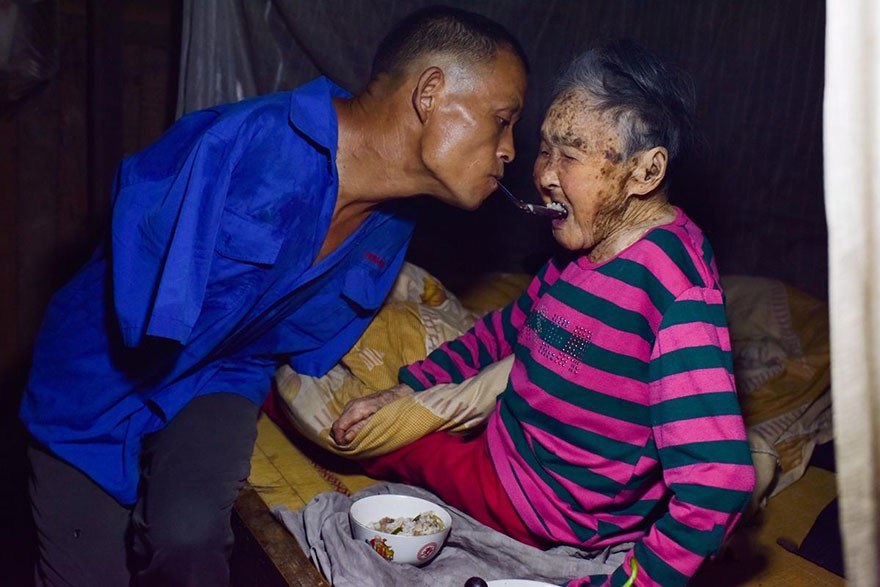 This is Chen Xinyin, a 48 year old with more than his fair share of troubles. Here he is spoon-feeding his now paralyzed mother a meal. As you can see Chen doesn’t have any arms.