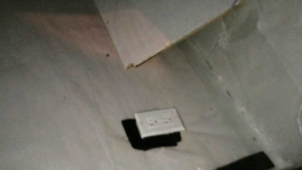 The walls, floor and ceiling are covered in soundproofing board and plastic tarp, all white. There are 3-4 outlets in the room with a small raised area the size of a single bed. Strange for a crawlspace