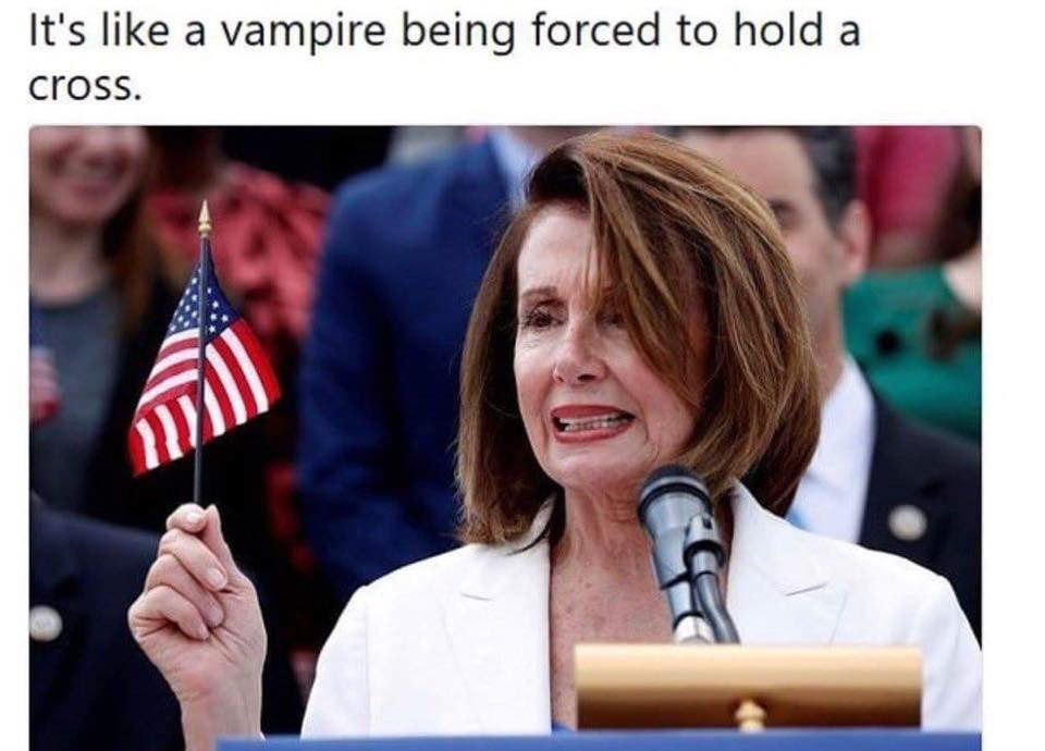 memes - nancy pelosi flag - It's a vampire being forced to hold a cross.