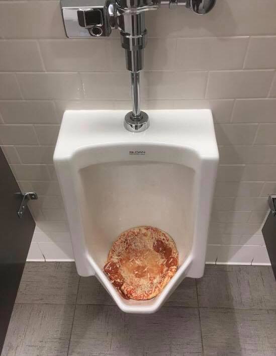 Pizza discarded in the urinal
