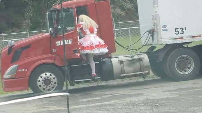 Girl in dress climbing into a truck to drive it