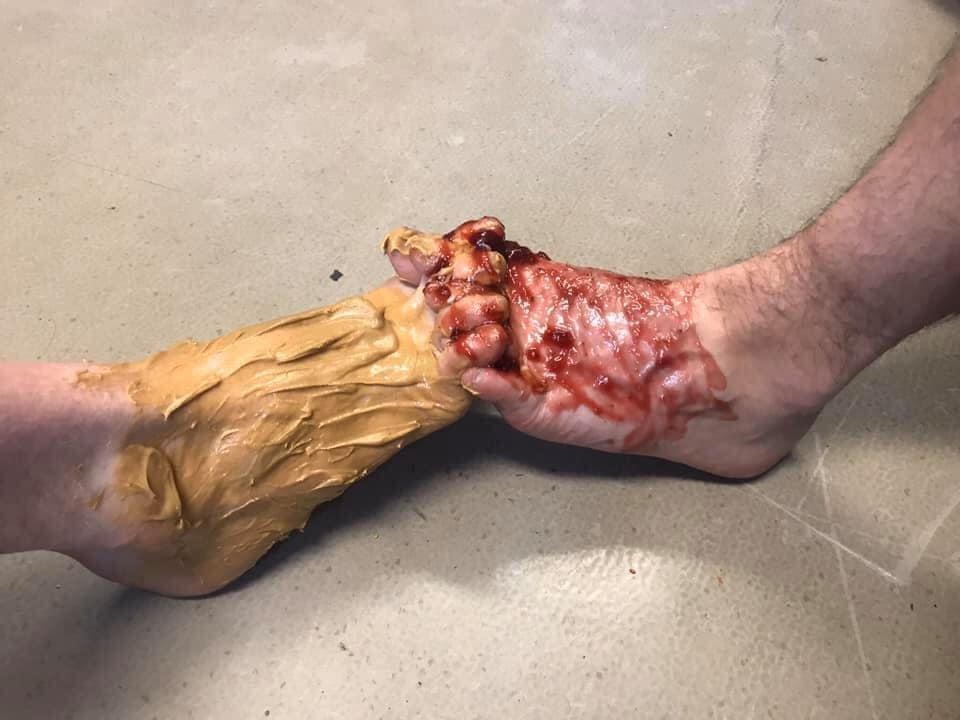 two feet covered in peanut butter and jelly interlocking toes