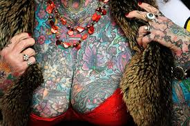 The 77-year-old made it into the Guinness World Records and was called a "legend" of the tattoo world.