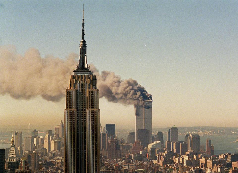 The twin towers of the World Trade Center burn behind the Empire State Building, Sept. 11, 2001