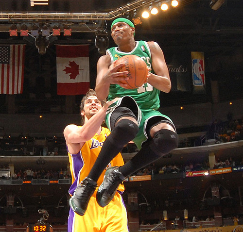 A lakers player gives a celtics player a helping hand to make a basket... Ok its just a good photo from a rebound but it looks like when a father helps his young kid make a basket by lifting him closer

here's the link to the original for the photoshop commenters
http://www.nba.com/finals2008/photos/finals_game4_11.html