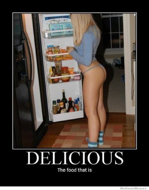 Delicious looking naked woman standing in front of the fridge.