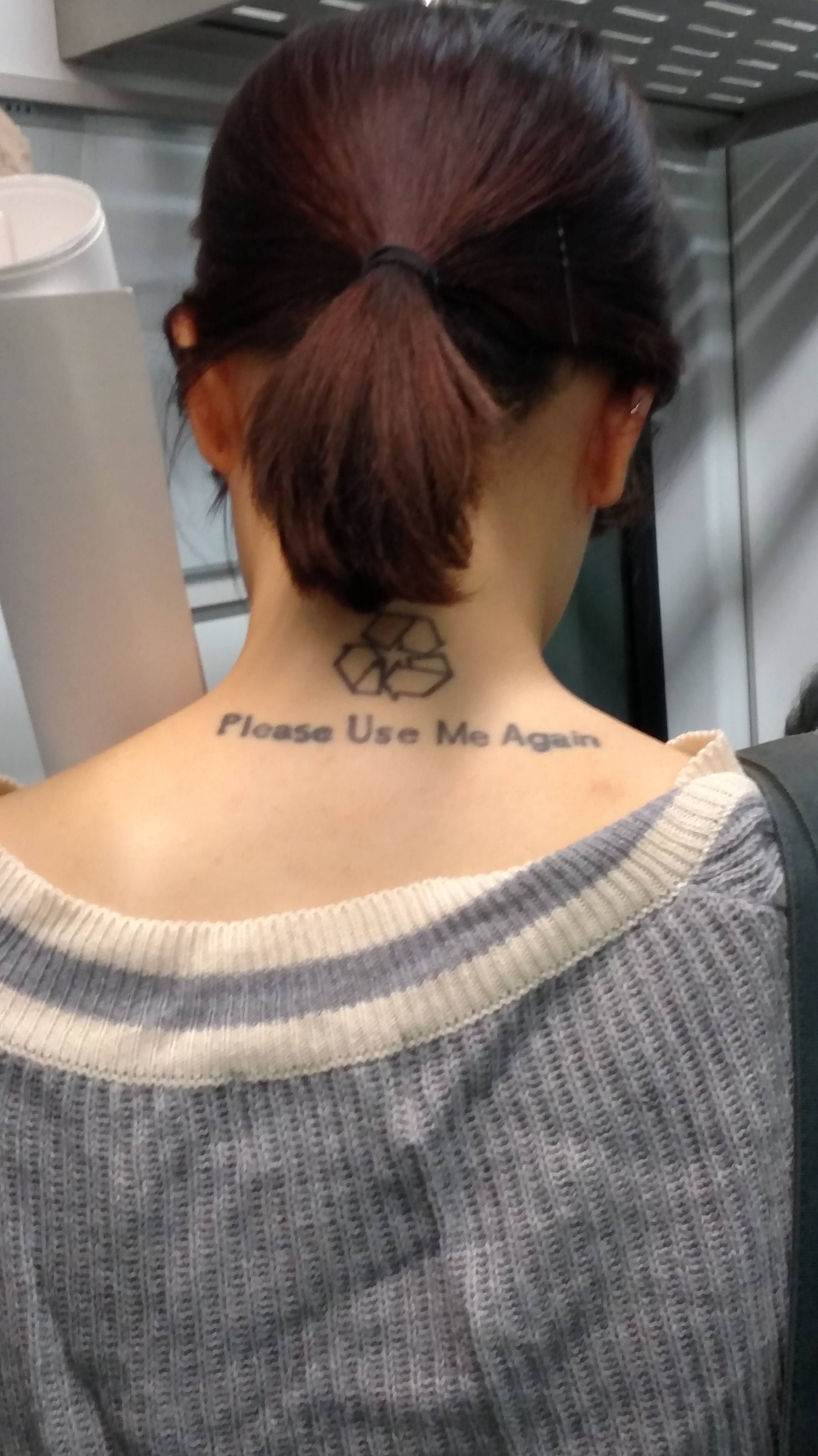 Girl with tattoo on the back of her neck that has recycled logo and says please use me again