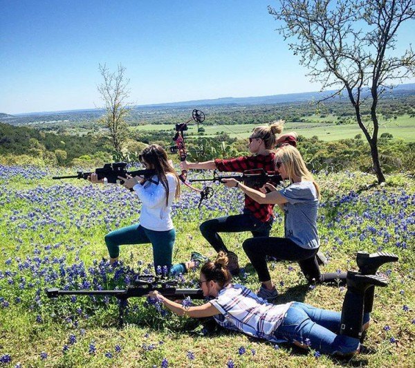 cool picture of 4 girls posing with rifles and archery