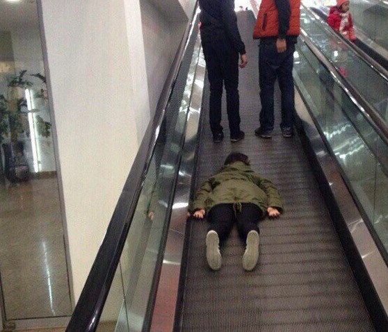 funny picture of planking on an escalator