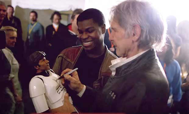 John Boyega gets an autograph from Harrison Ford.