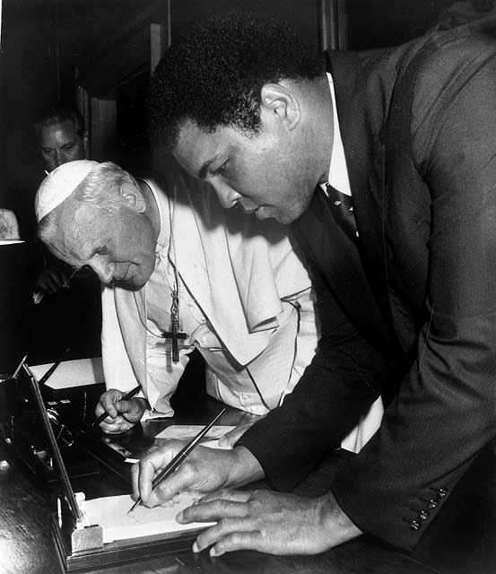 Muhammad Ali signs an autograph for Pope John Paul II.