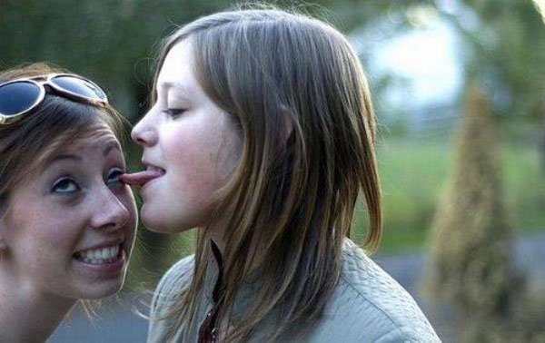 random woman licking friend's face