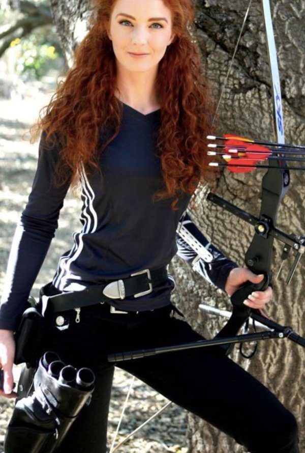 Red curly haired girl with bow and arrow.