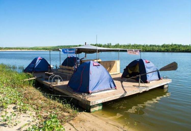 Floating platform with camping tents on it.
