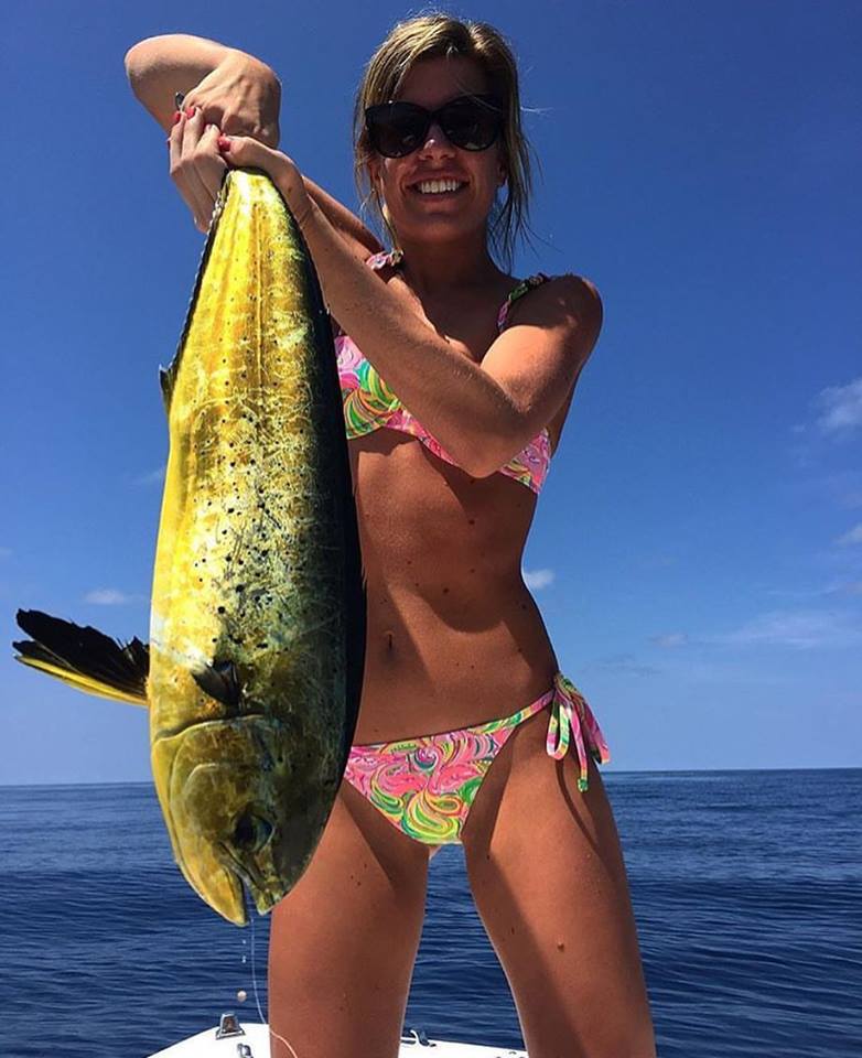 Picture of a girl in Bikini holding up a large fish.