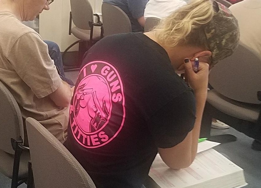 Girl wearing a shirt in class that says Guns N' Titties