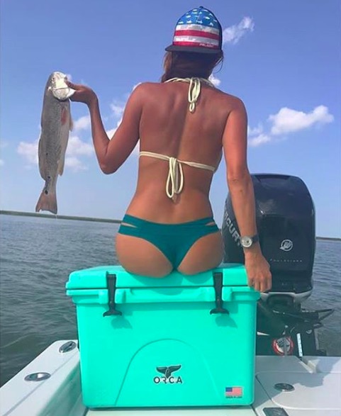 Cute girl showing off her fish she caught.