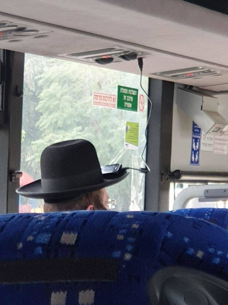 guy charging his phone on the bus