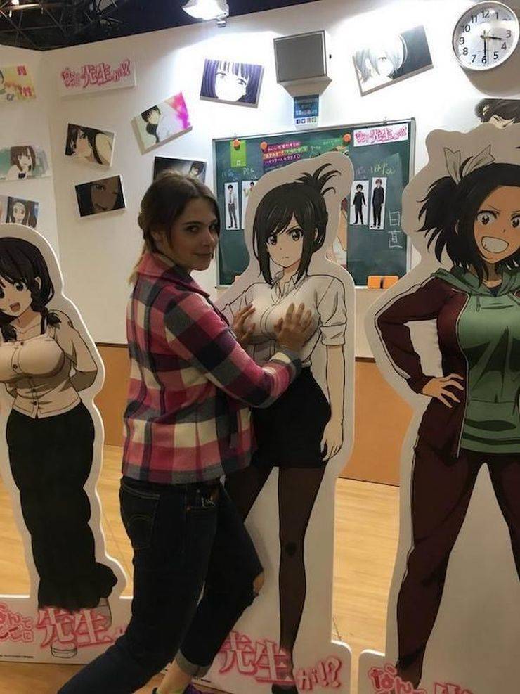 funny pics and memes - Woman grabbing the breasts of an anime character cutout