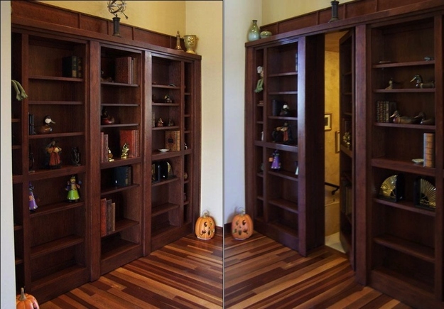 A concealed bookshelf door into a basement space.