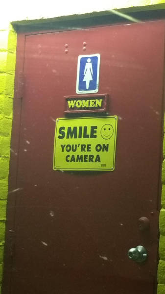signage - Women Smile You'Re On Camera