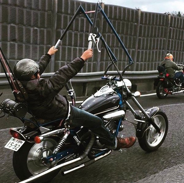 Man on a chopper motorcycle with very elaborate and tall handlebars