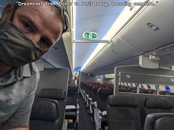 guy on empty airplane wearing a mask