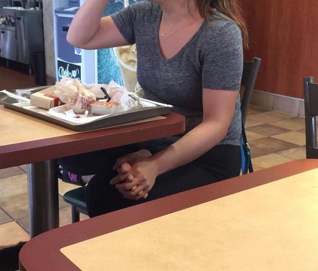 girl holding her own foot while eating