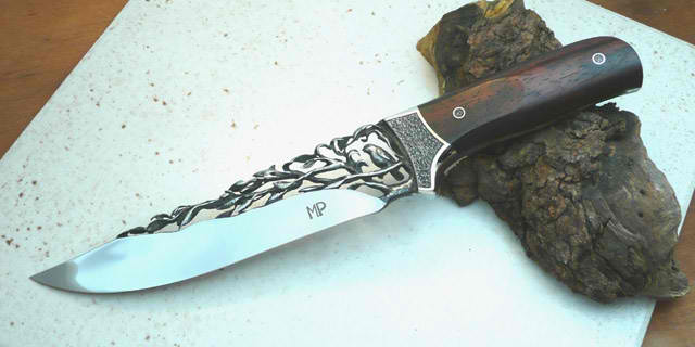 made by Miguel Pennacchioni. look close.. the steel blade is actually carved not engraved.