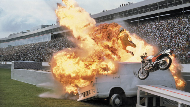 Setting himself on fire, motorcycle stuntman Dennis Pinto drove full speed into the side of a van landing still smoldering in a pile of cardboard boxes on the other side.