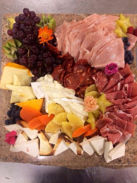 This plate of cheeses, meats, and fruits.