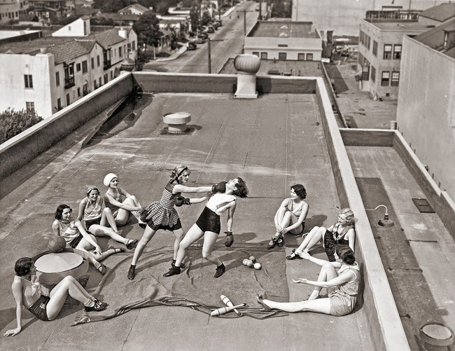 A woman throws a killer right while boxing on a rooftop in the 1930s.