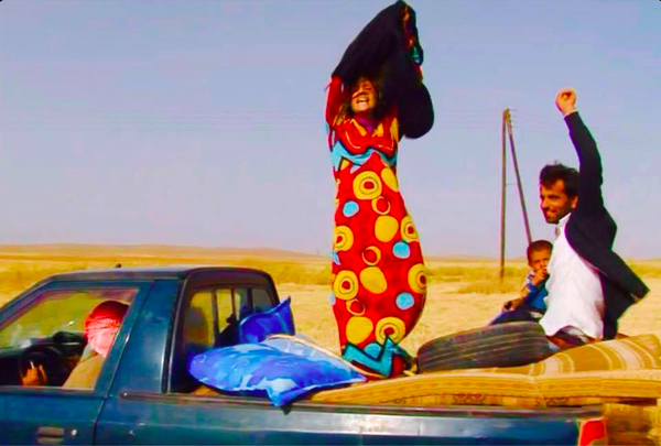 Two women fleeing extremist areas throws off her black abaya when reaching a safety checkpoint.