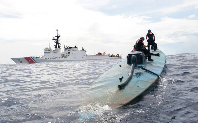 A boarding team from U.S. Coast Guard cutter Stratton investigates a self-propelled semi-submersible in international waters off the coast of Central America. The seizure of around 12,000 pounds of cocaine from the vessel was one of the largest busts of its kind.