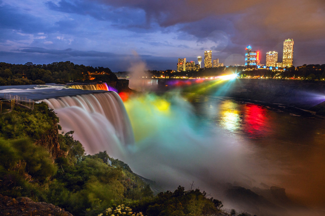 Niagara Falls absorbing the colorful city lights.