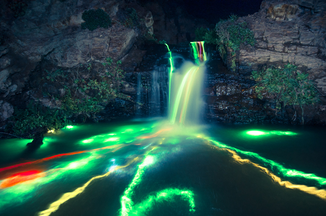 Glow sticks drift down a waterfall.