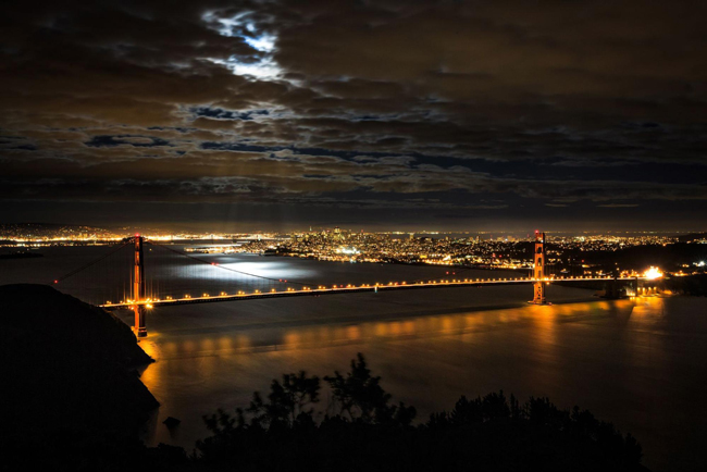 The moonlight shining through the clouds over the Golden Gate Bridge in San Francisco.