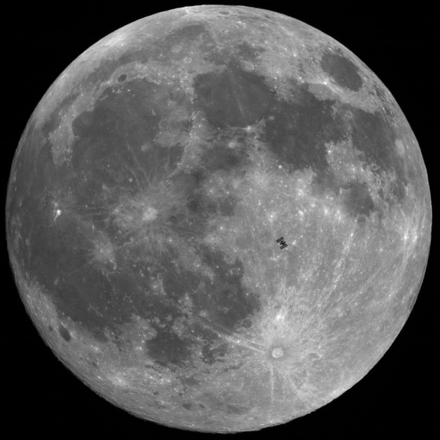 The International Space Station in front of the full moon.