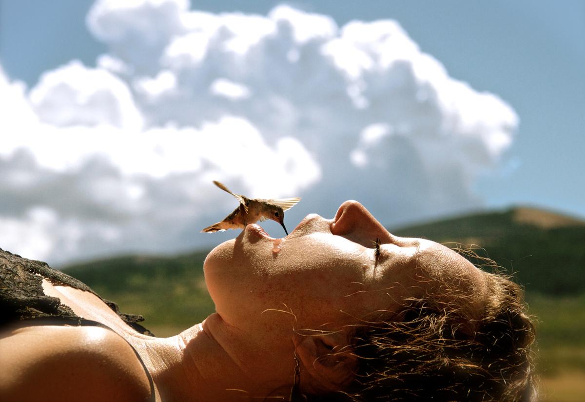 A very hungry humming bird drinking from the mouth of a person in Wyoming during an extreme drought in 2012.