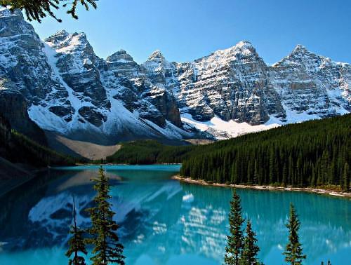 Moraine Lake, Banff National Park, CanadaBright water, green pines, and snow-capped mountains.