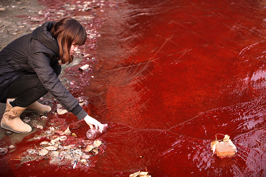 Journalist Takes Sample Of Red Polluted Water From The Jianhe River